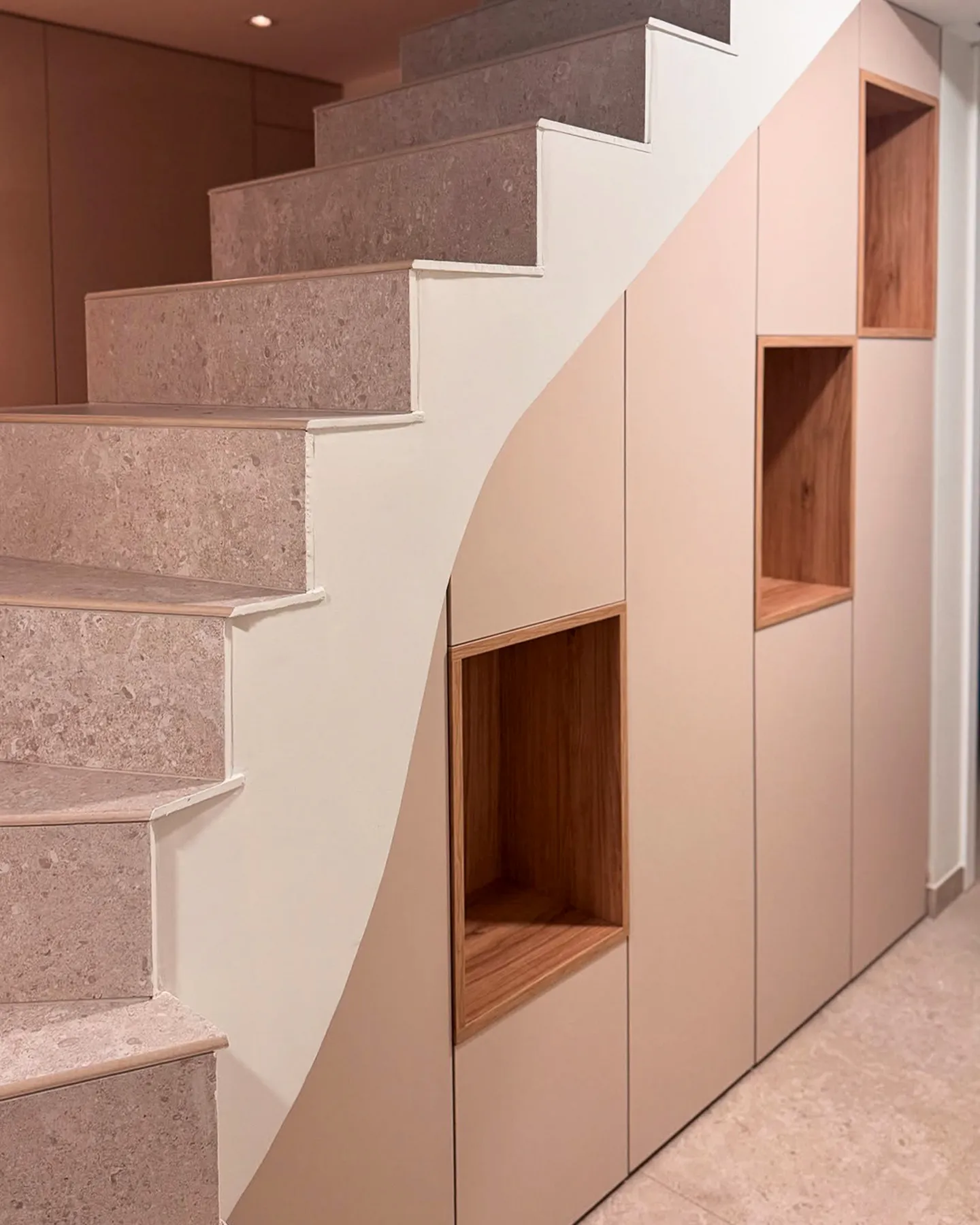 Meuble sous escalier sur mesure avec façades unies et niches ouvertes en décor bois
