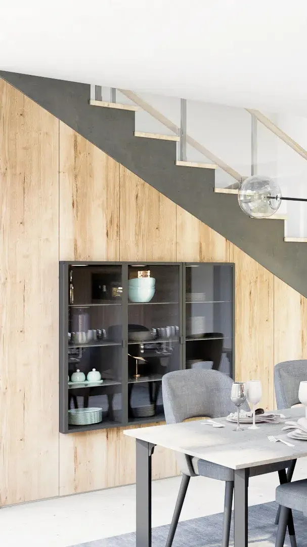 Aménagement sur mesure sous escalier avec façades bois clair, vitrines intégrées et rangements pour salle à manger.