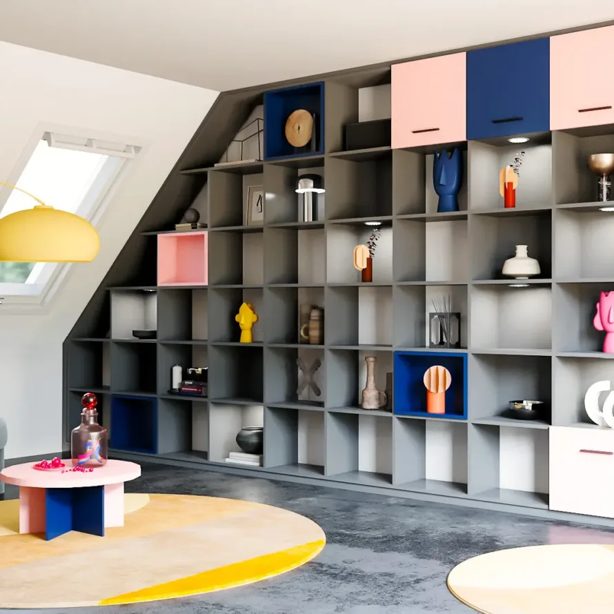 Bibliothèque sur mesure sous combles avec niches décoratives, façades colorées et rangements fermés.