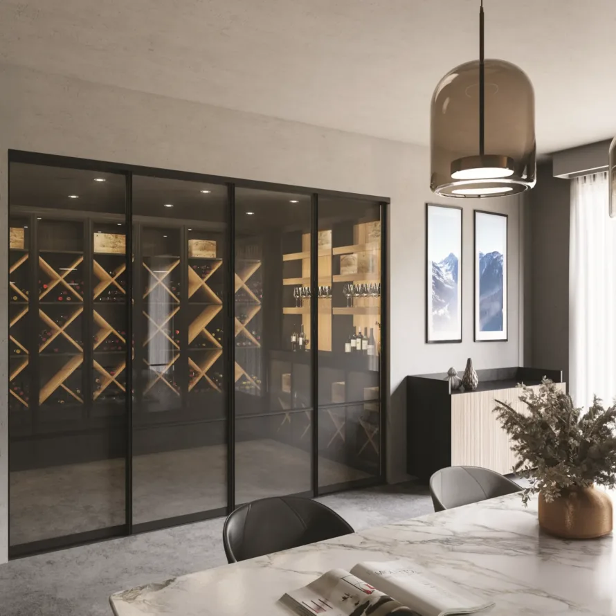 Cave à vin sur mesure avec portes vitrées coulissantes, casiers bois, éclairage intégré et espace dégustation attenant.
