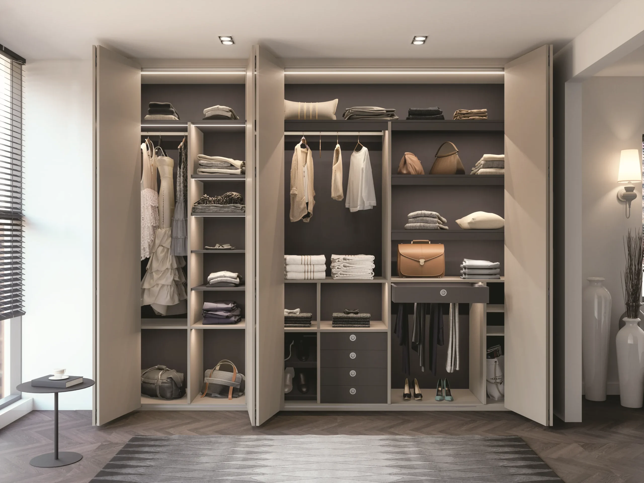 Dressing sur mesure avec portes pliantes ouvertes, penderies, étagères, tiroirs et éclairage intégré dans une chambre contemporaine.