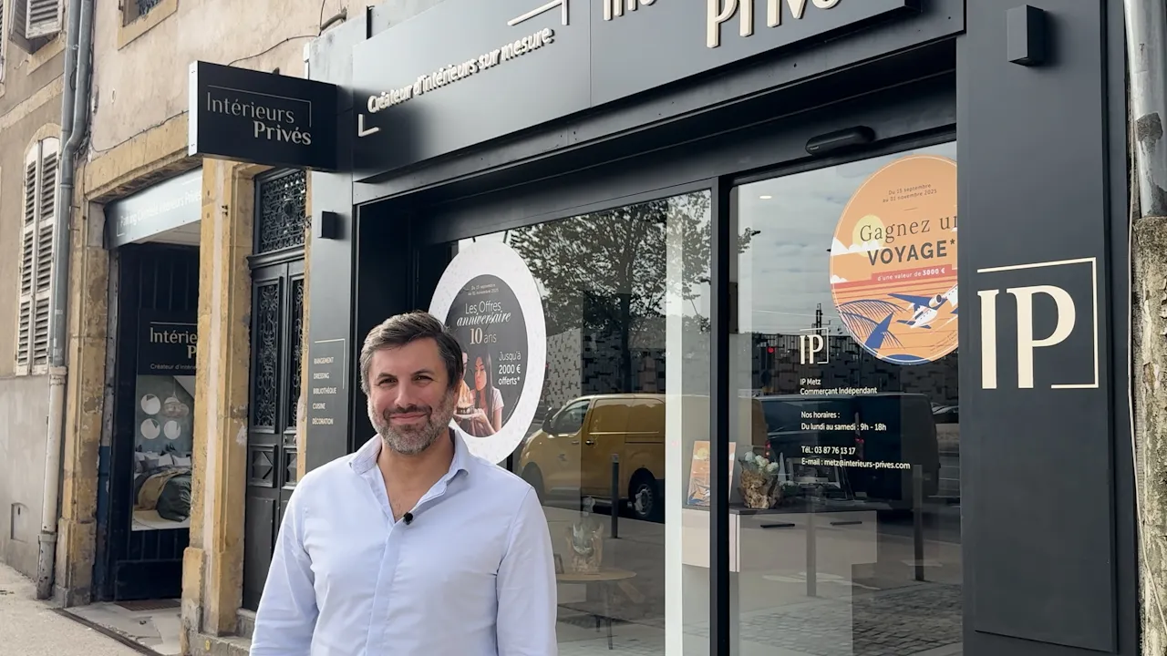 Emmanuel Mendonca, concepteur-agenceur, posant devant la façade noire du magasin Intérieurs Privés de Metz, avec l'enseigne et la vitrine visibles en arrière-plan