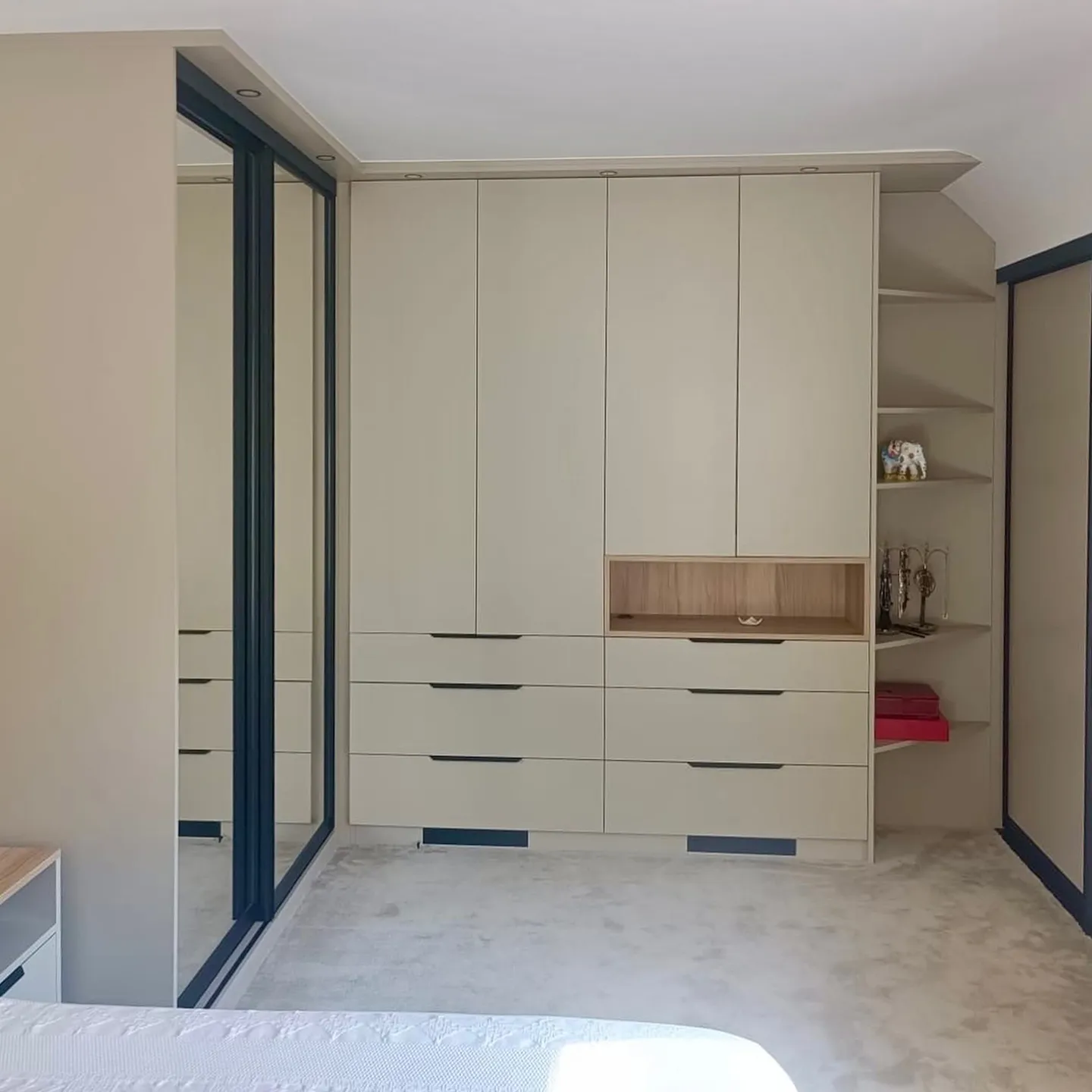 Dressing sur mesure en façade beige avec tiroirs, penderies et niche bois décorative dans une chambre à Sèvres.