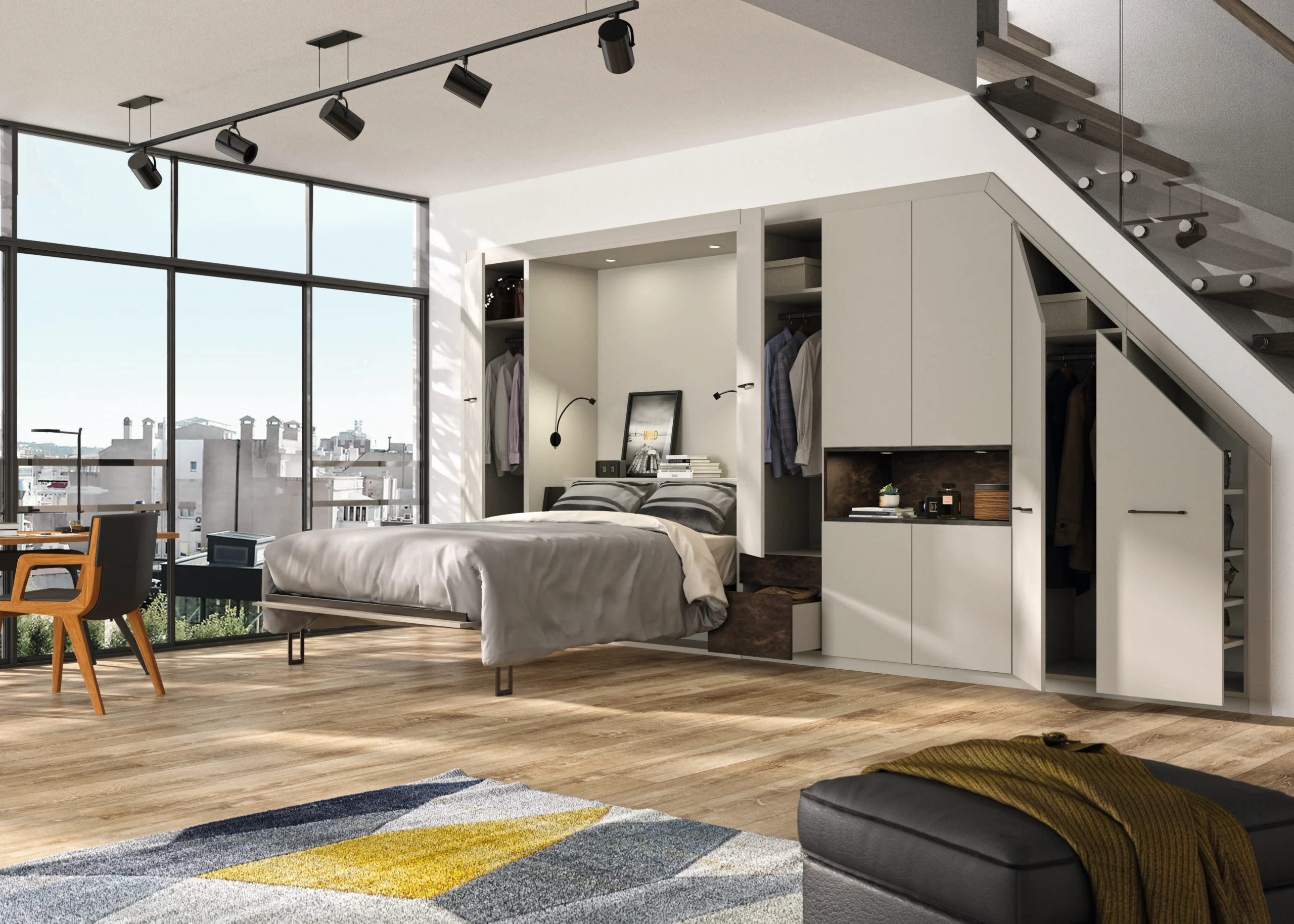 Lit rabattable sur mesure ouvert dans un studio lumineux, avec rangements intégrés sous escalier, penderies et niches décoratives.