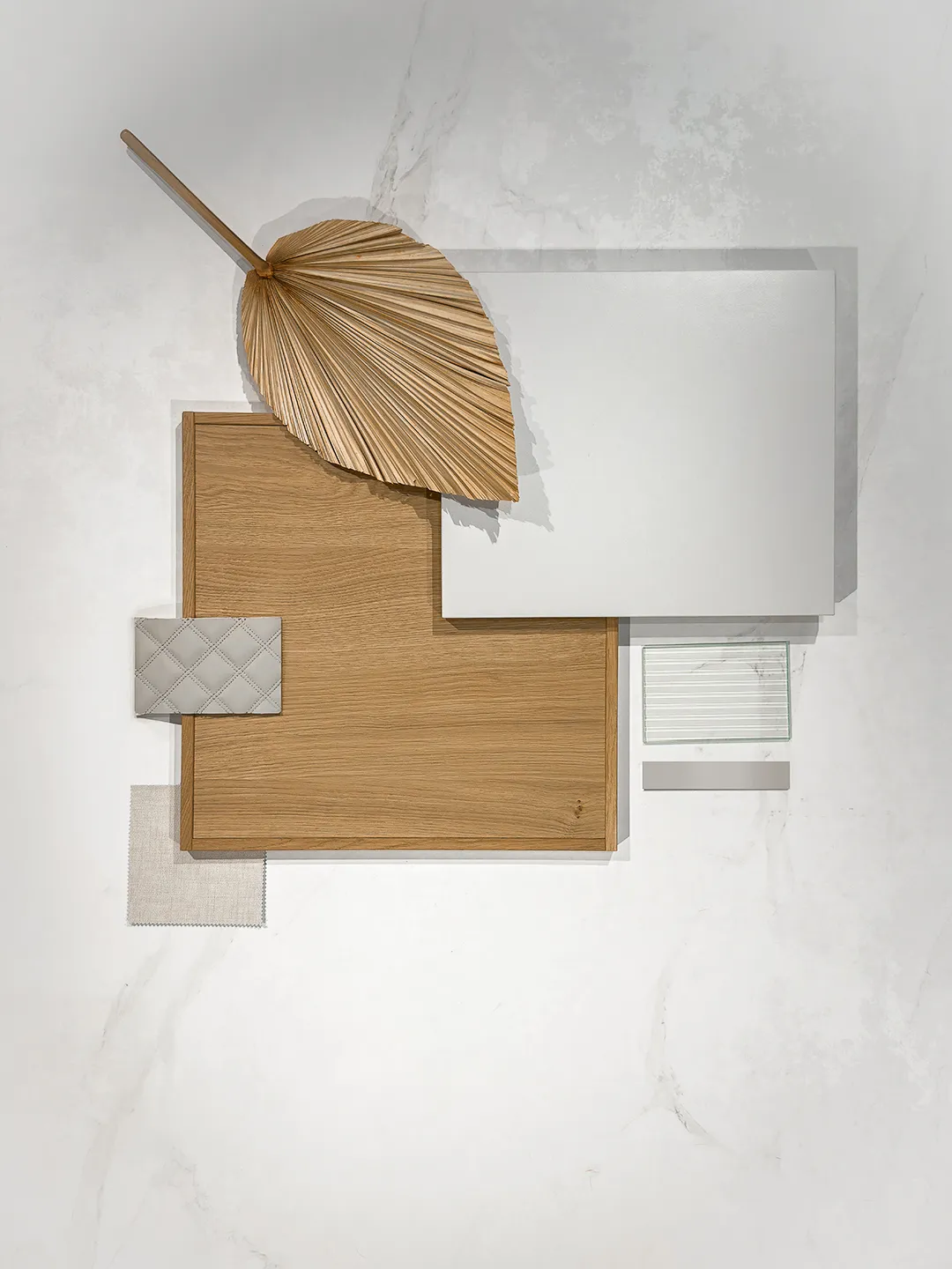 Planche tendance Japandi avec bois clair, matières naturelles, blanc, textile et feuille décorative.