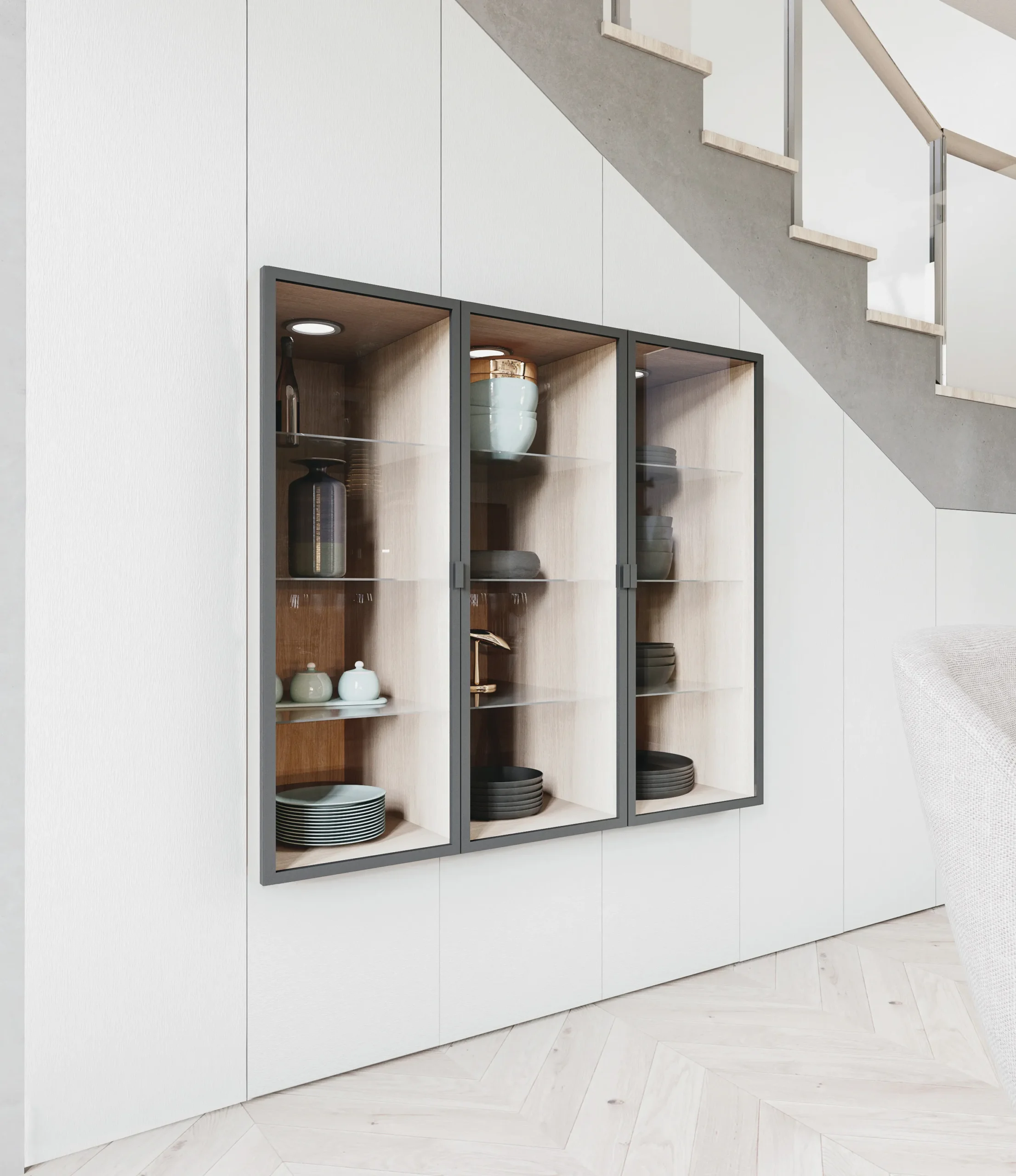 Rangement sous escalier sur mesure avec façades blanches, vitrines éclairées et niches décor bois pour la vaisselle.