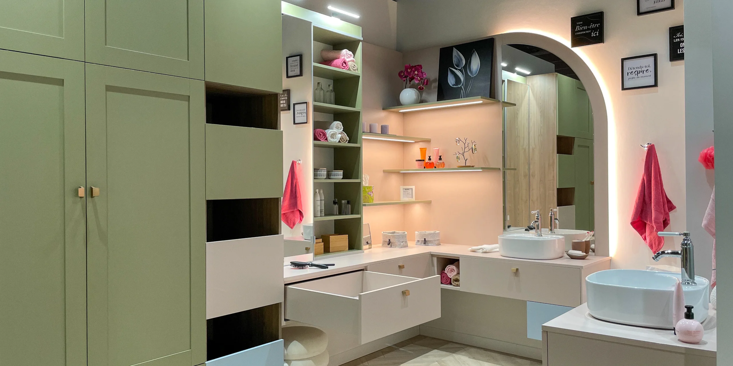 Salle de bain sur-mesure avec meuble vasque, tiroirs suspendus, miroir lumineux et rangements vert sauge.