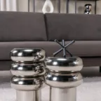 Tables d’appoint chromées aux formes arrondies devant un canapé gris, pour une décoration intérieure moderne et raffinée.