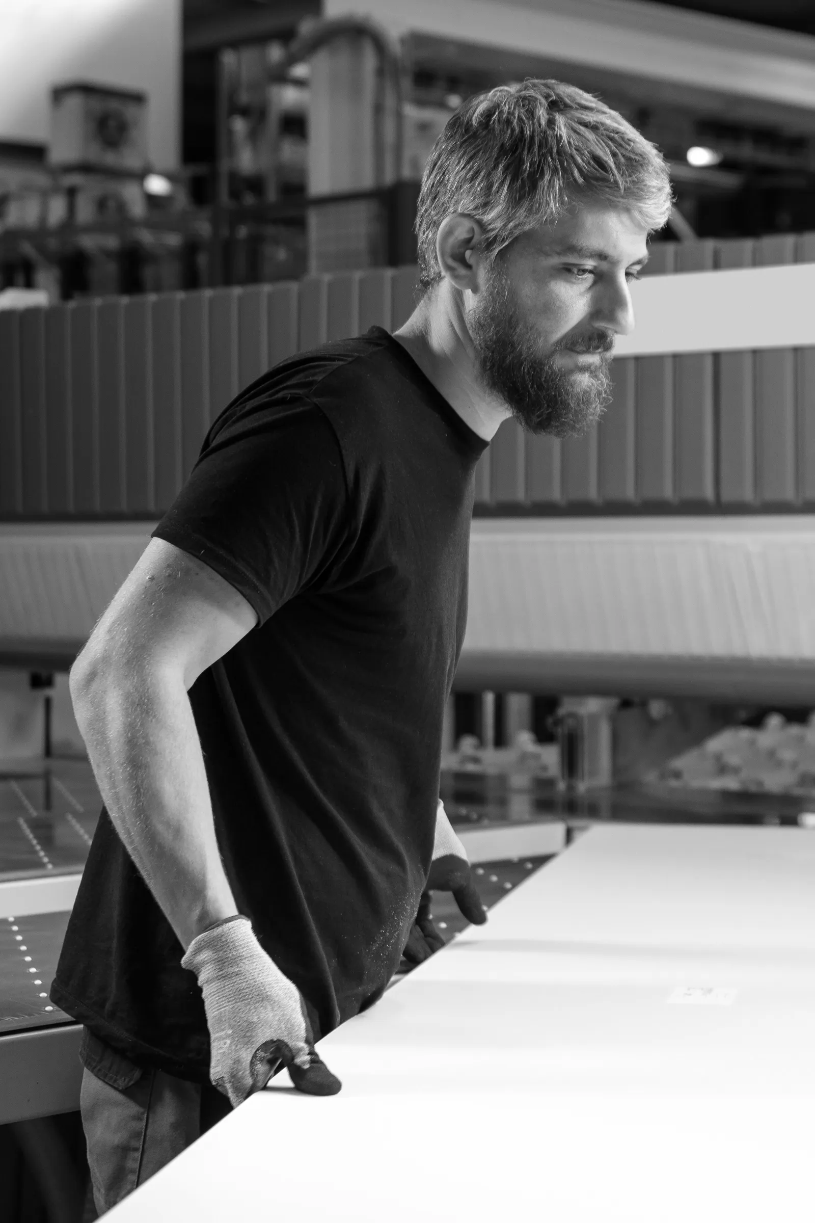 Professionnel en atelier préparant un panneau pour la fabrication d’un aménagement intérieur sur mesure.